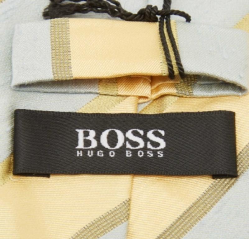 Elige esta corbata Boss By Hugo Boss para dar a tu look formal un toque de lujo. Está cortado en seda y adornado con rayas por todas partes. Lleva la etiqueta de la marca en la parte posterior.