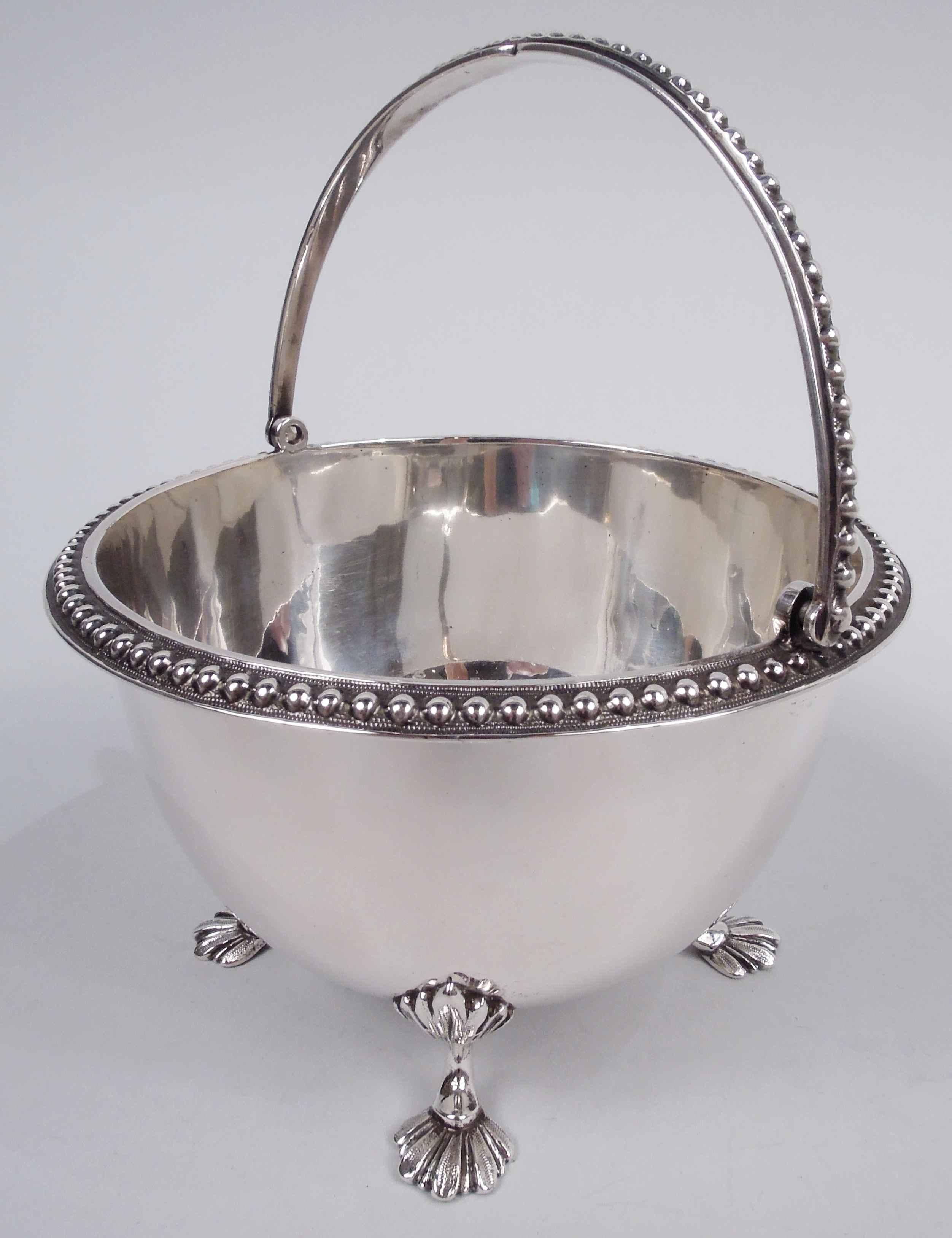 Classical coin silver basket. Made by Haddock, Lincoln & Foss in Boston, ca 1860. Round and curved with four cast leaf-mounted leaf supports. Beaded mouth rim and c-scroll swing handle. Marked with maker’s stamp. Weight: 8.2 troy ounces. 