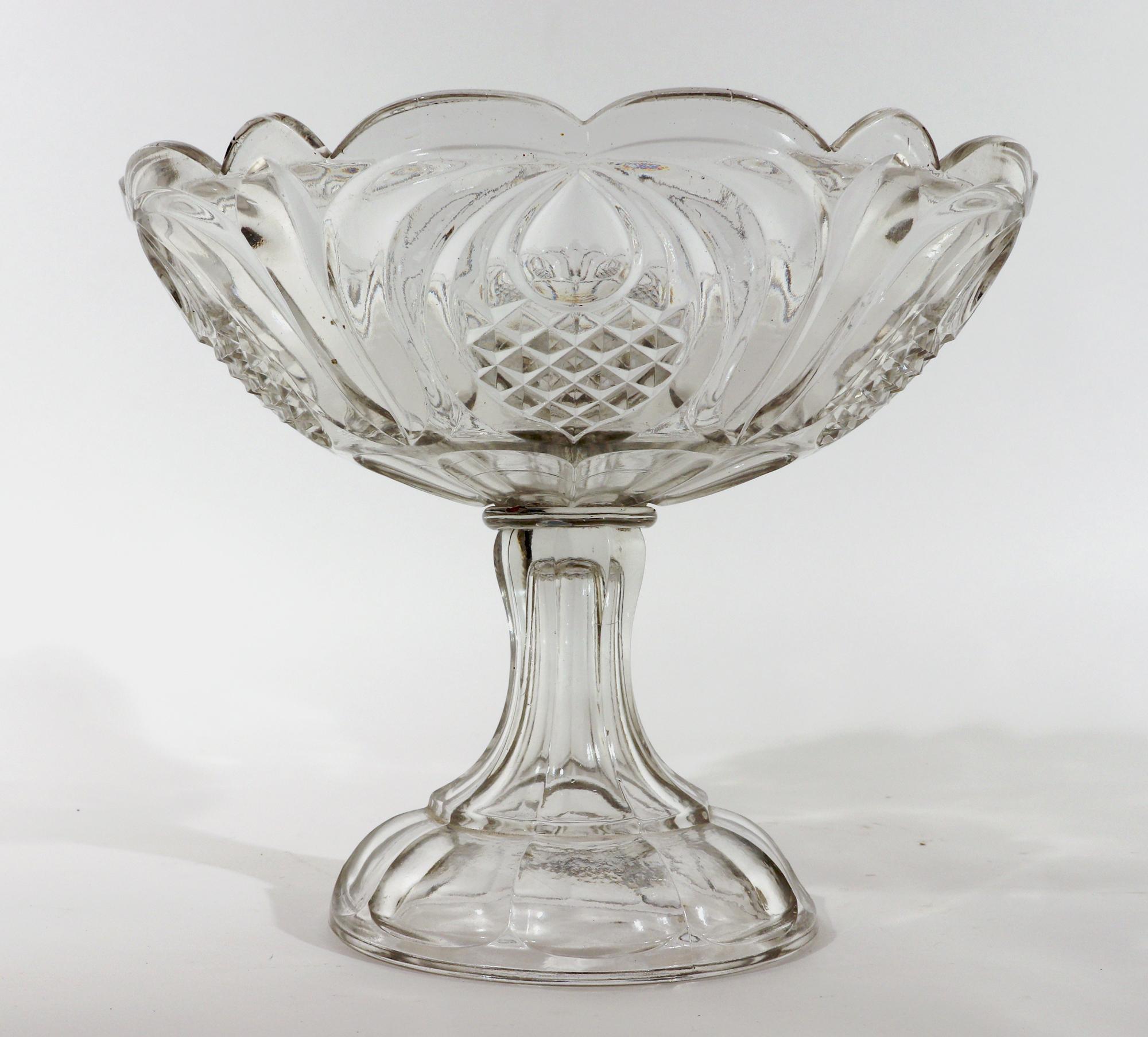 Boston & Sandwich American Pressed Glass Compote,
Pineapple Pattern,
Circa 1860's

The pressed lead glass compote is made in the Pineapple pattern made circa 1860.  It has a tall hollow flaring foot and the bowl has a shaped edge.  There are six