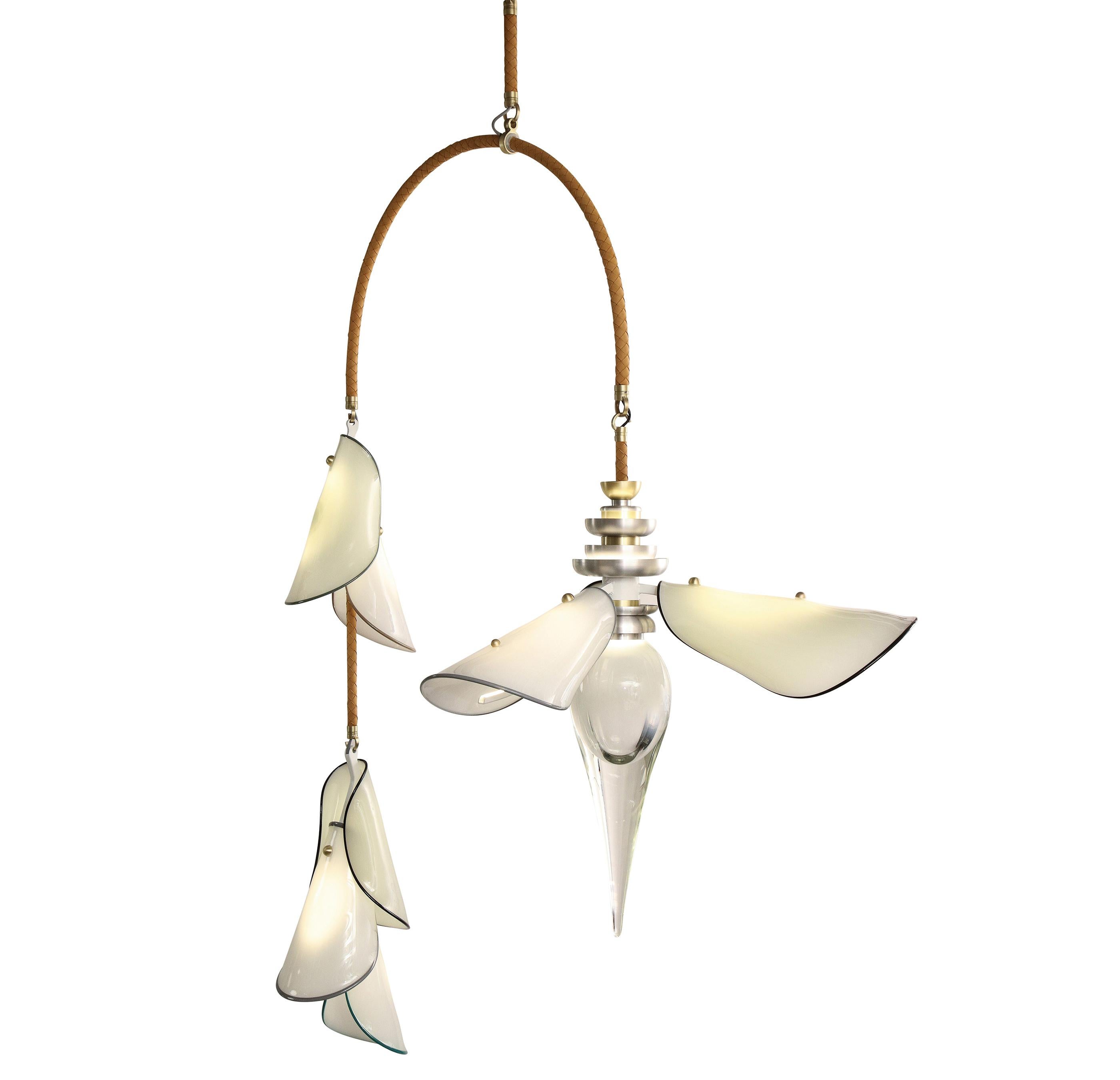 The Botanica Chandelier combines a dramatically scaled floral bloom with an interlocking chain of glass leaves suspended from a single arc clad in hand woven leather. Inspired by banana flowers and Lisbon’s famed botanical gardens founded in 1878,