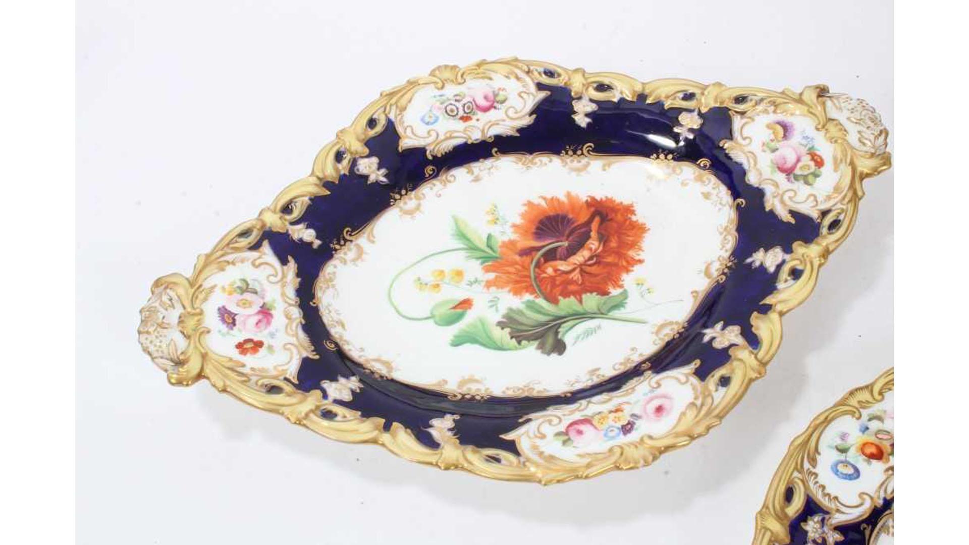 A coalport dessert service by Stephen Lawrence, circa 1840, the moulded rims picked out in yellow and gilt, the centres finely painted with botanical studies to reserves edged in gilt against a dark blue ground. 

Service comprising 10 dessert