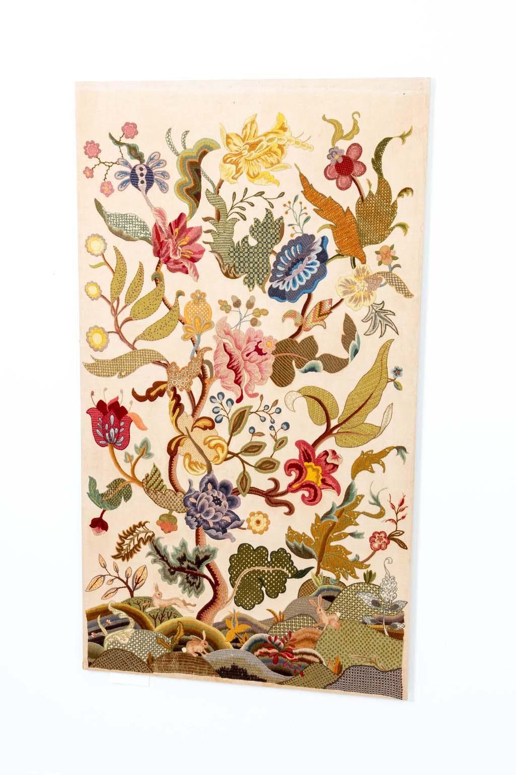 An early Jacobean embroidery textile of botanical crewel work using various stitches and colors.  Jacobean Crewel Embroidery is a form of crewel embroidery characterized by fanciful plant and animal shapes worked in a variety of stitches with wool