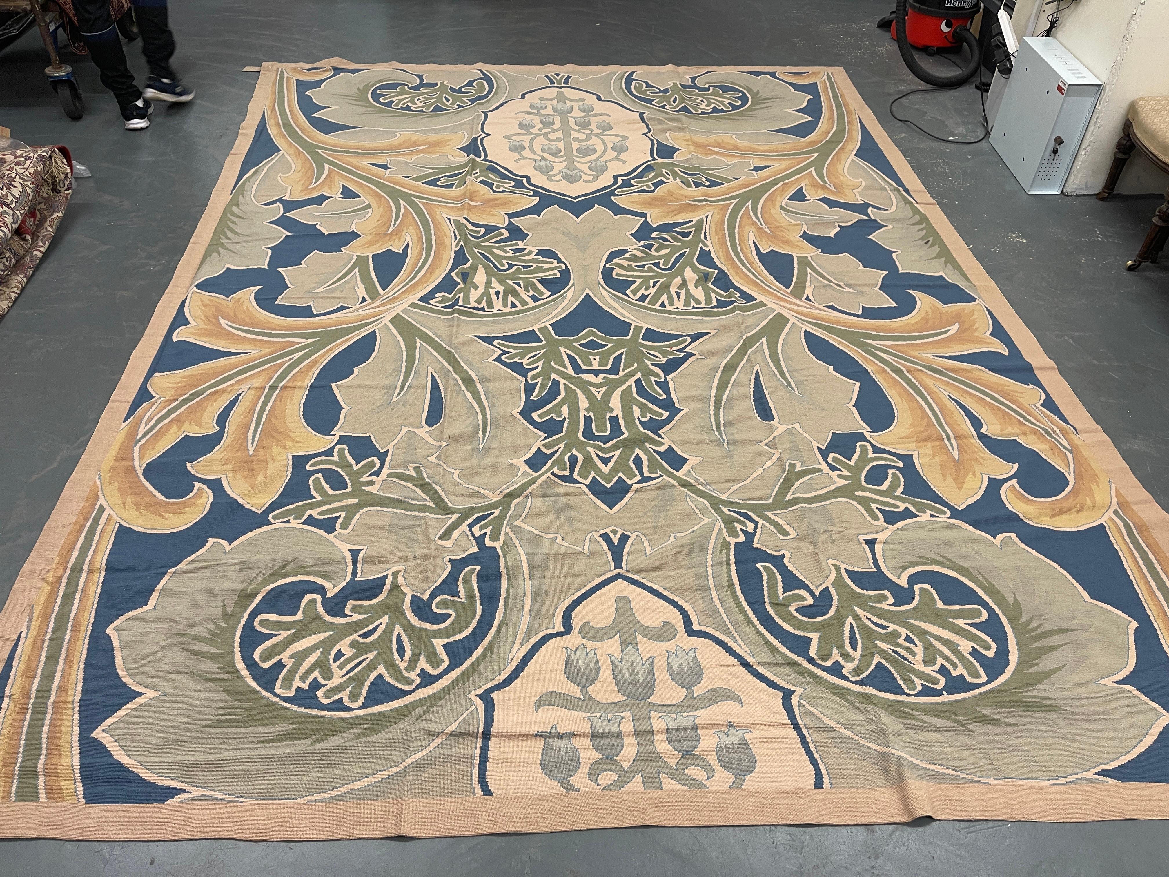 Ce magnifique tapis a été tissé à la main avec un magnifique motif botanique symétrique à grande échelle sur un fond bleu/vert ivoire avec des accents de vert crème et d'ivoire. La couleur et le design de cette pièce élégante en font le tapis