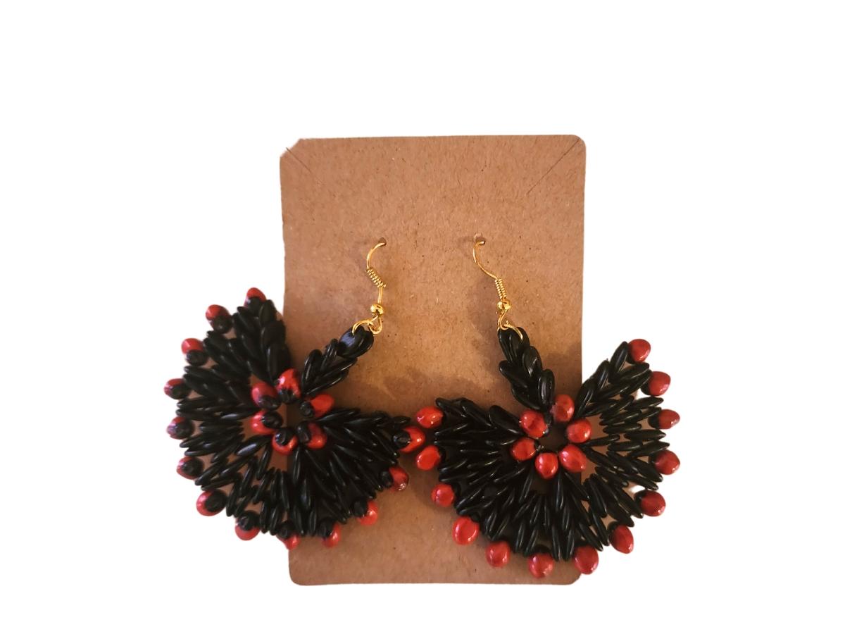 The Botanique Crimson Bloom Earrings are an exquisite representation of nature’s vibrant colors and intricate design, featuring a radiant combination of black tamarind seeds and striking red jumbie beads. Each earring fans out like a blossoming