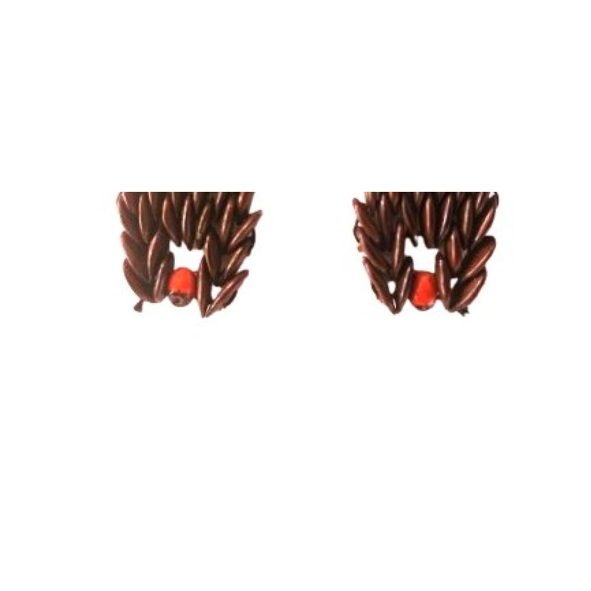 The Crimson Cascade Earrings are an elegant representation of nature’s charm, combining deep brown wild tamarind seeds and a single radiant red jumbie bead at the top of each earring. The cascading layers of the tamarind seeds evoke the flowing