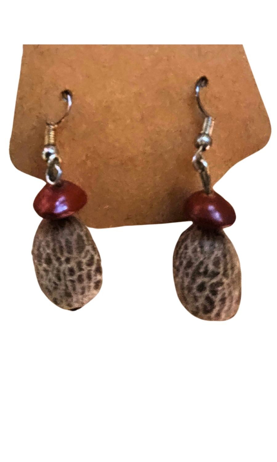 The Earthbound Harmony Earrings beautifully combine the natural textures of a palm seed and a tamarind seed, showcasing the organic elegance of Antigua and Barbuda’s abundant flora. With their earthy tones and simple yet captivating design, these