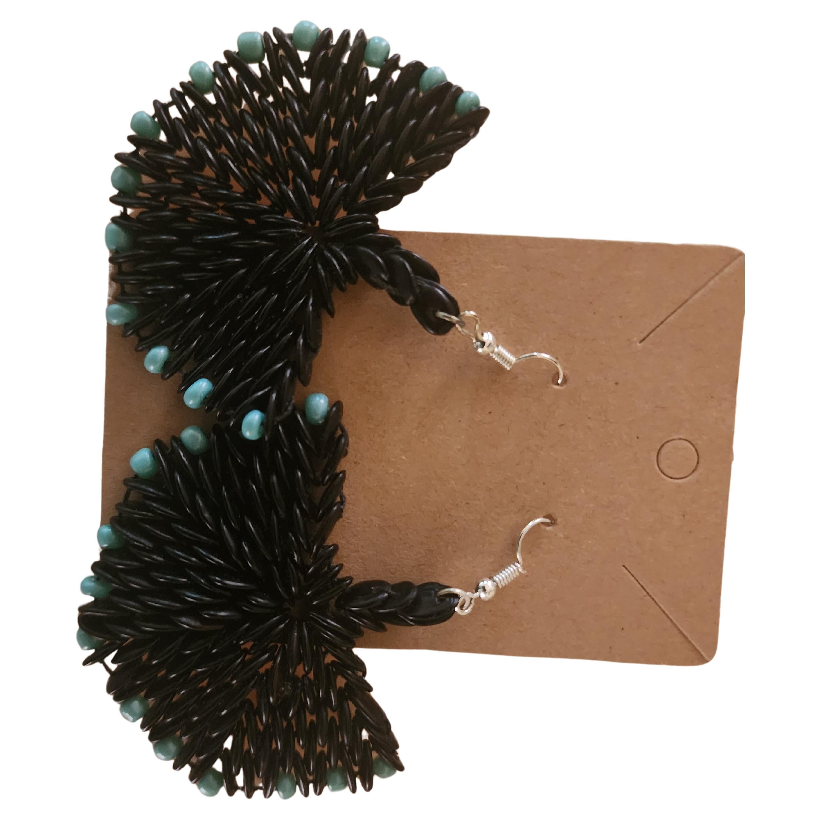The Botanique Ebony Crescent Earrings are a captivating fusion of nature’s elegance and artisanal craftsmanship, embodying the essence of Botanique’s commitment to showcasing the beauty of natural materials. These distinctive earrings feature