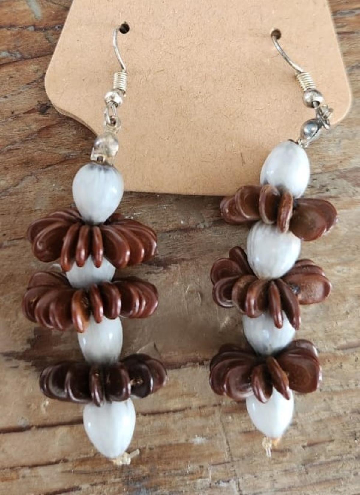 Botanique Tamarind Tears is a stunning handmade earring design crafted with locally harvested brown wild tamarind seeds and Job’s tears seeds. This exquisite piece reflects a deep connection to Antigua and Barbuda’s African heritage, where the art