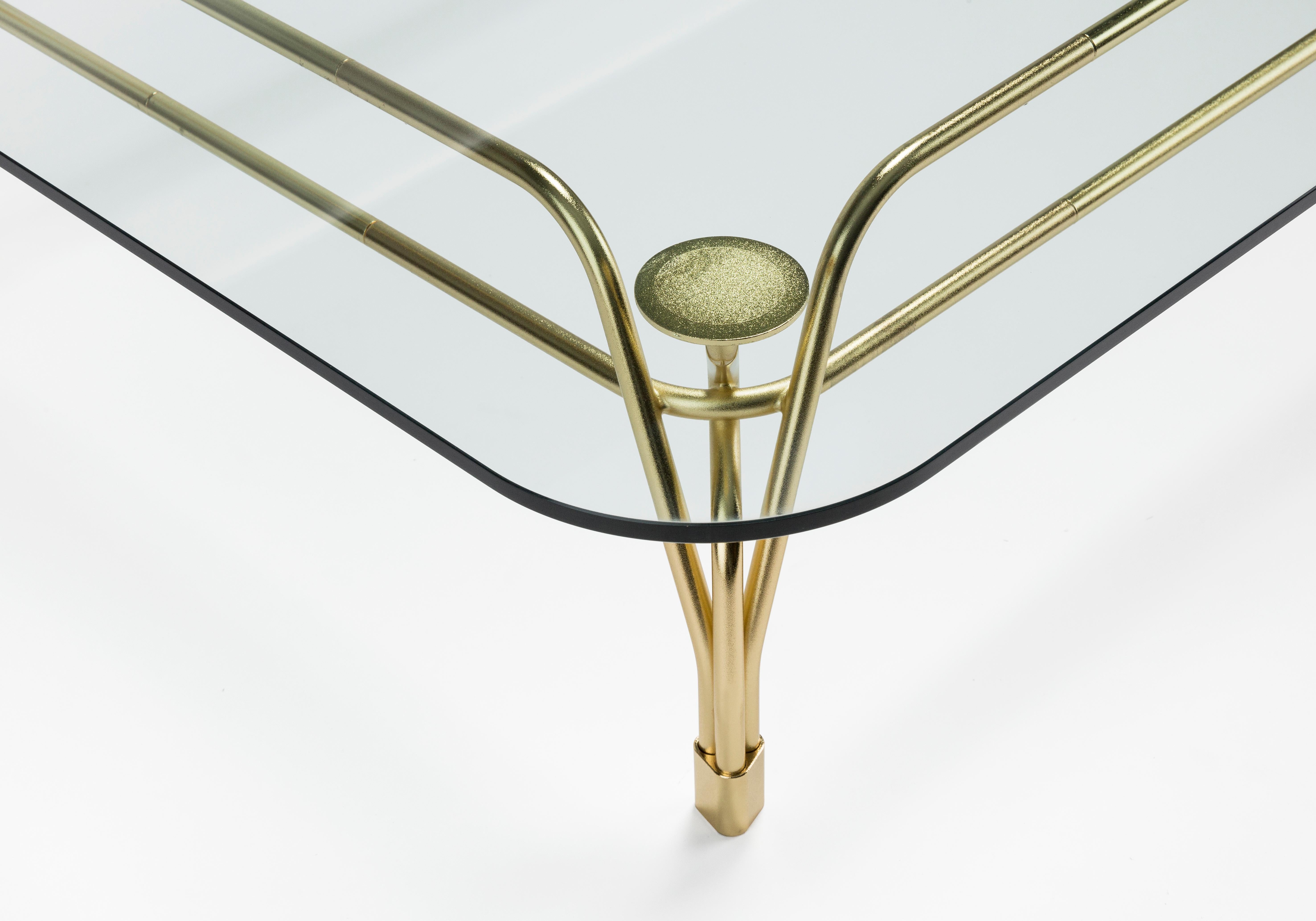 Famille de tables caractérisée par l'élégante structure métallique sophistiquée soutenant le plateau en verre. L'inspiration des meubles d'extérieur du début du siècle rencontre l'artisanat moderne du métal de haute qualité. Le tissage complexe de
