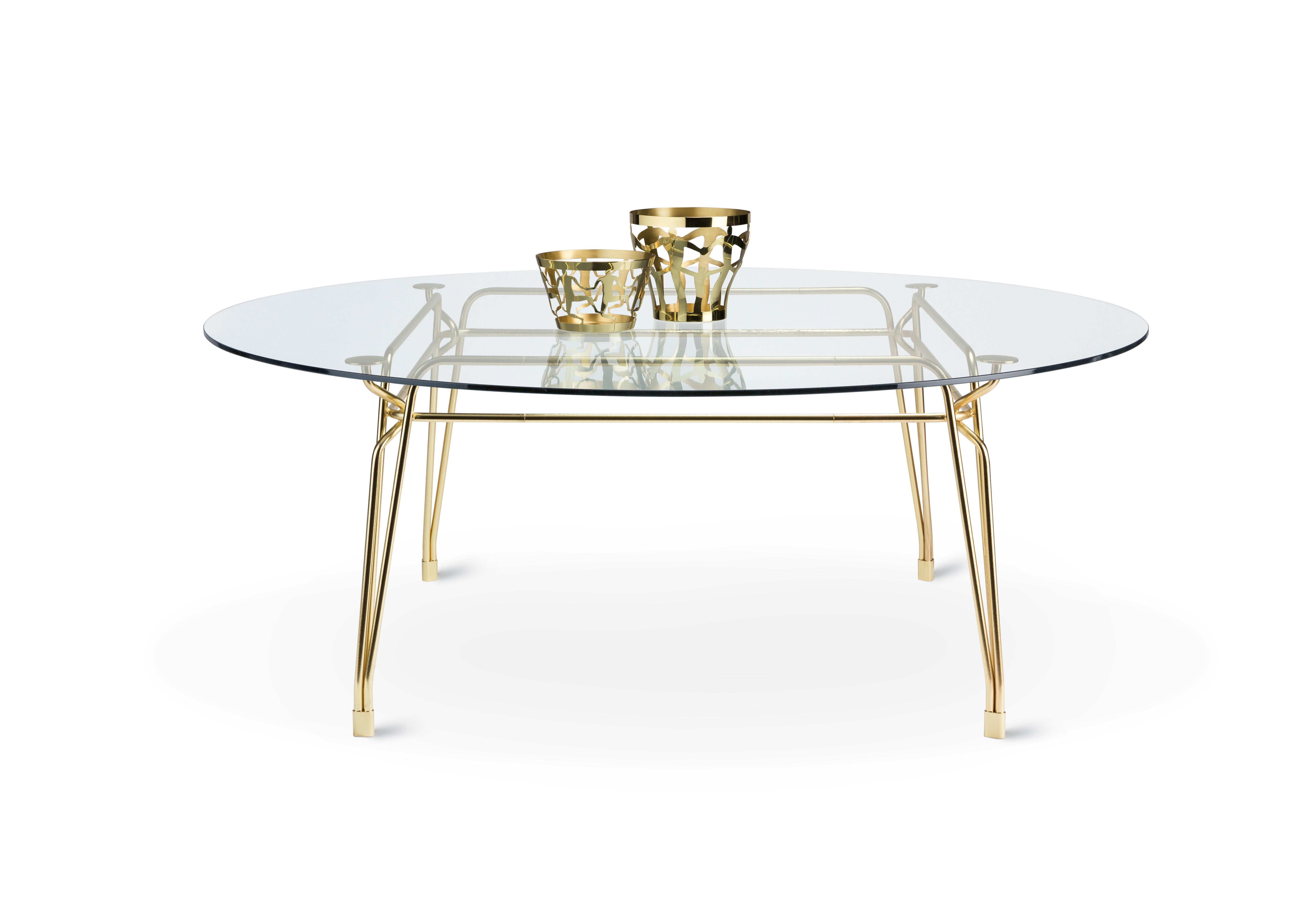 Family of tables characterized by the elegant sophisticated metal structure supporting the glass tabletop. Inspiration from turn of century outdoor furniture meets modern high-quality metal crafting. Intricate weaving of steel rods creates a
