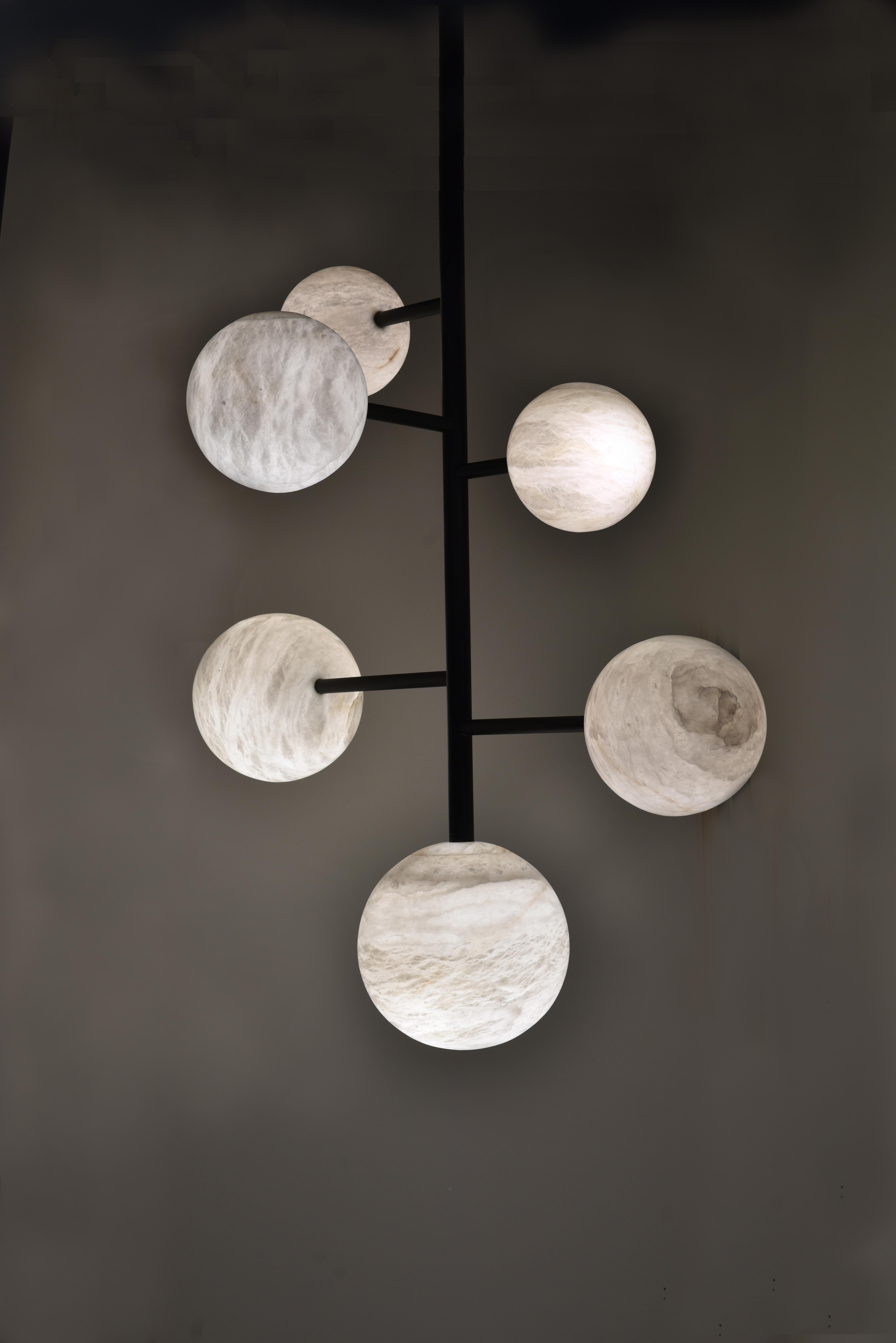 Botero chandelier by Atelier Alain Ellouz
Collection Atelier 
© Atelier Alain Ellouz
Dimensions: Ø 51.2’’ x 70’’
Materials: Alabaster, steel painted matte black 
Weight: 132 lb.

Like atoms, Botero’s spheres are arranged in molecules of light. The