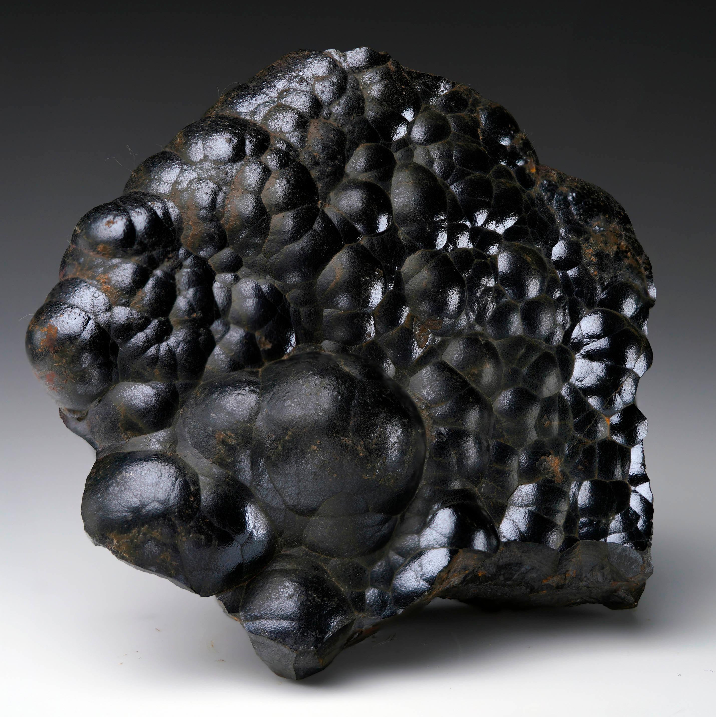 Questo straordinario esemplare di ematite proveniente dal Marocco mostra un'incantevole lucentezza naturale sui contorni fluidi e arrotondati della struttura cristallina botrioidale a grappolo. La forma scultorea unica nel suo genere e la densità di