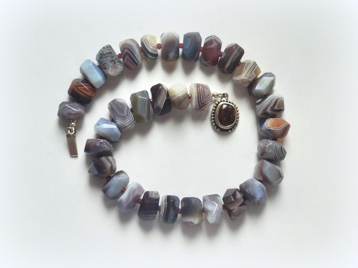 The length of the necklace is 17.5 inches (44.5 cm). The size of the beads is 13-16 mm x 17-19 mm.

Botswana Agate is a variety of banded Chalcedony, a mineral of the Quartz family. It is predominantly banded in pink and gray shades, though some