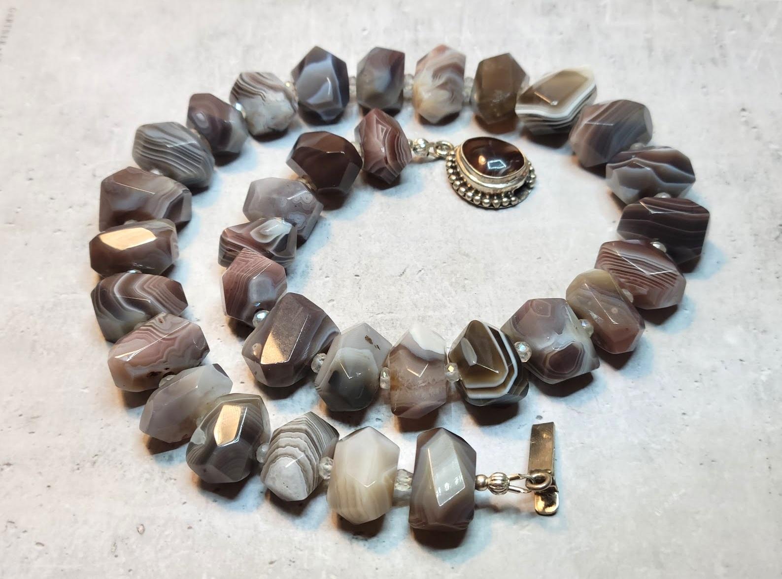The length of the necklace is 19 inches (48 cm). The size of the beads is 11-15 mm x 17-20 mm.

Botswana Agate is a variety of banded Chalcedony, a mineral of the Quartz family. It is predominantly banded in pink and gray shades, though some layers