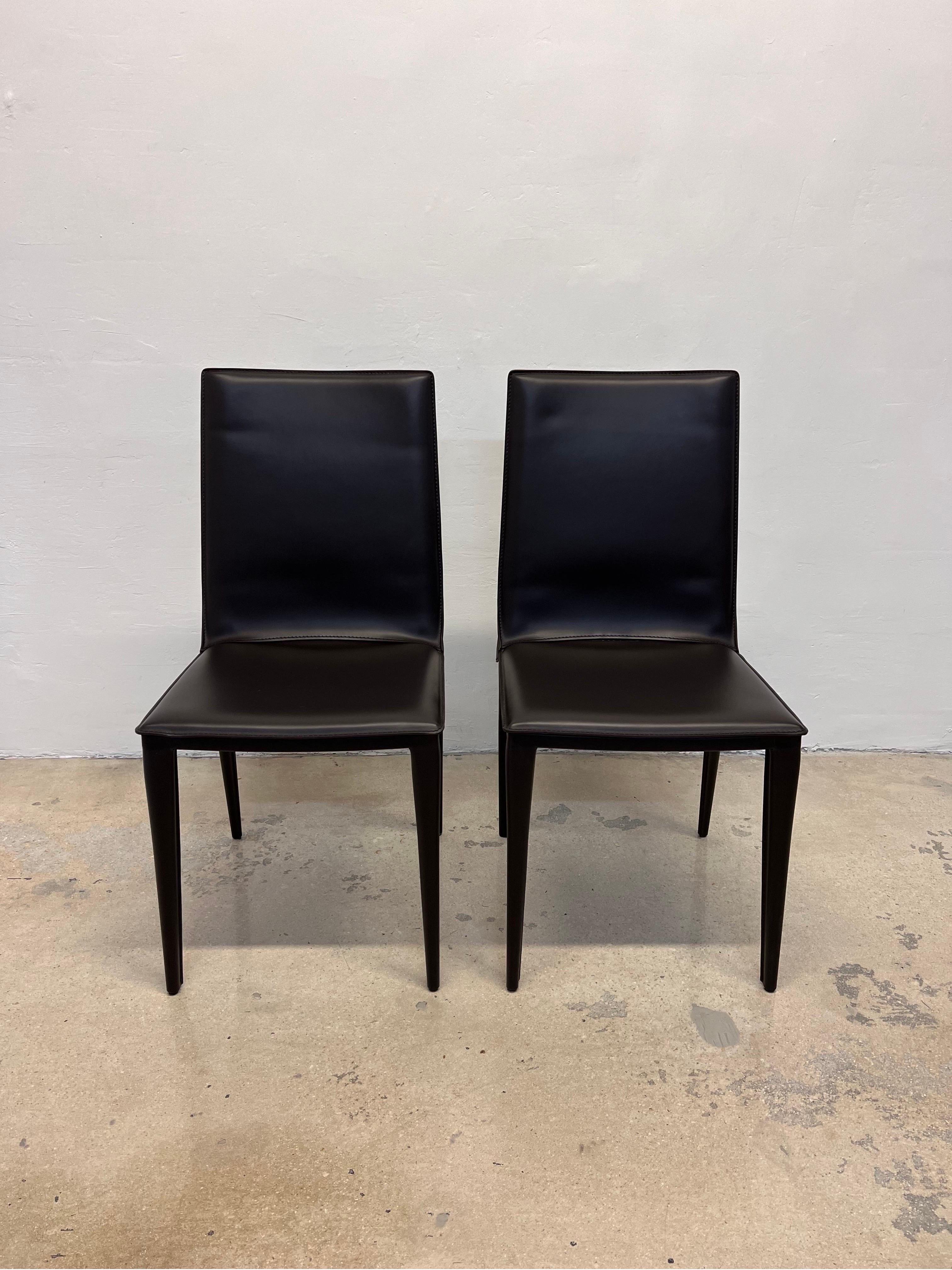 Pair of chocolate brown leather Bottega side chairs designed by Renzo Fauciglietti & Graziella Bianchi for Design Within Reach. 

Bottega Chair (2003) is constructed with a harmonic sheet steel back that flexes with you for continuous support.