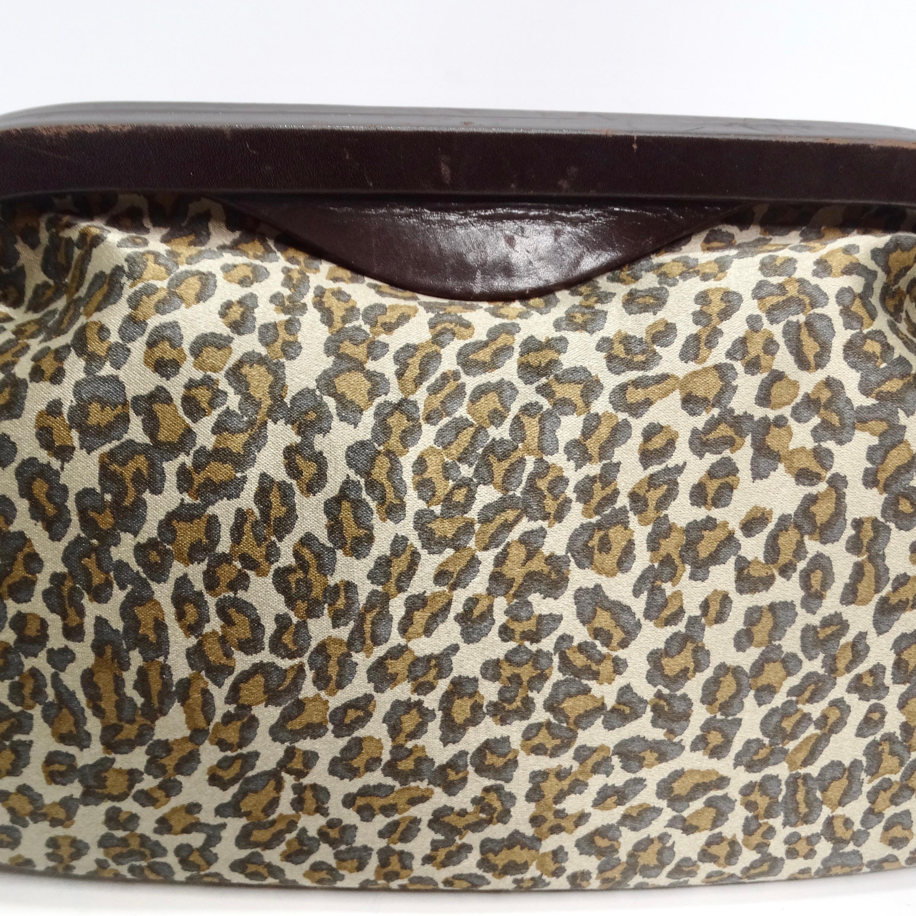 Introducing a clutch that's not just an accessory, but a work of art - the Bottega Veneta 1980s Leopard Print Satin Clutch. This classic mini clutch features a leopard print satin design, a brown wood magnetic closure, and a vibrant red leather