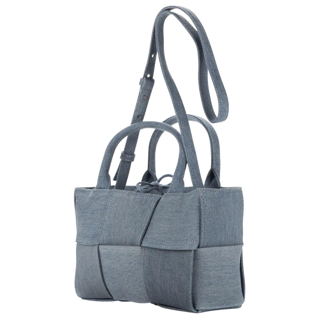 This Bottega Veneta tote in baby blue denim merges casual style with luxury. Featuring silver-tone hardware, its open-top design leads to a denim-lined interior, embodying effortless chic.

SPECIFICS
Length: 10.2