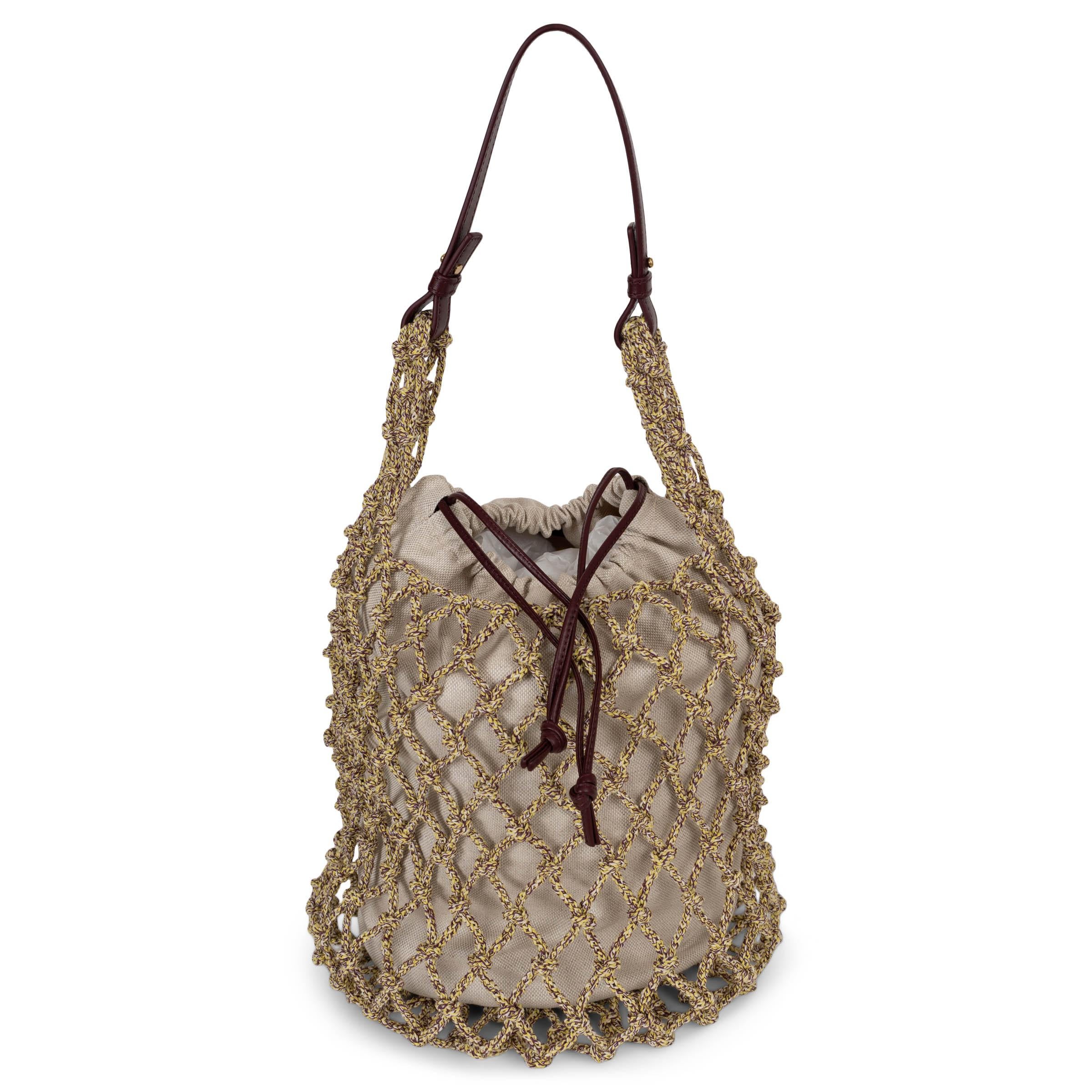 Diese 100% authentische Bottega Veneta Salina Tasche hat ein Makramee-Netz aus gelbem, weißem und burgunderrotem Seil mit einem eleganten Griff aus burgunderrotem Kalbsleder. Abgerundet wird das Design durch eine Tasche mit Kordelzug aus Segeltuch,