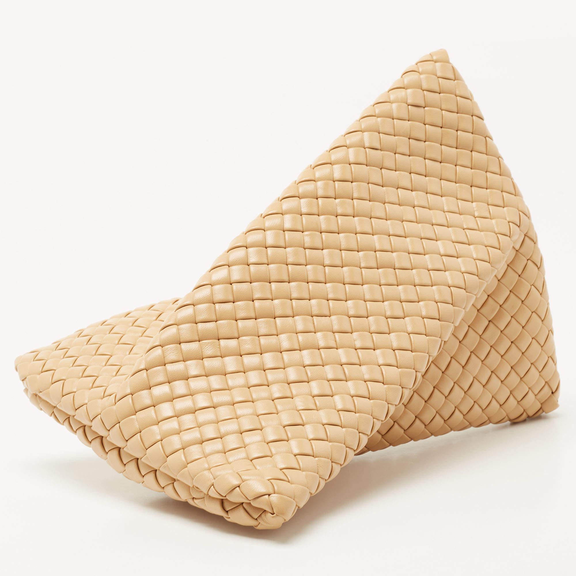 Playing with shapes, Bottega Veneta has created handbags that have enticed fashionistas around the world! One such is this criss-cross-shaped clutch made using leather in the Intrecciato weave. The pretty beige hue gives the silhouette a feminine