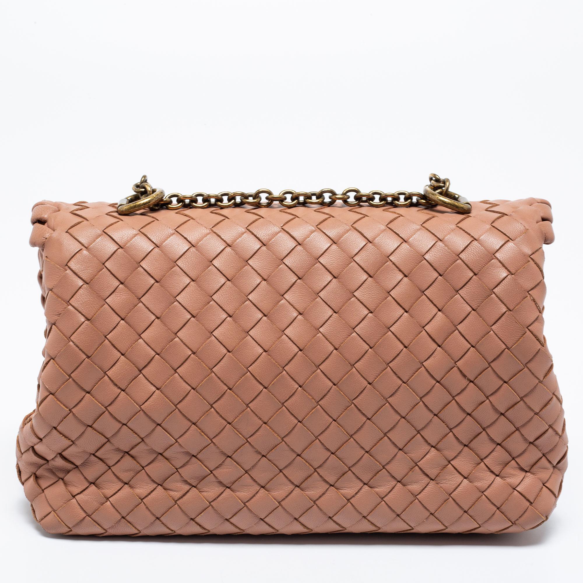 Let this cute and classy Olimpia shoulder bag from the House of Bottega Veneta elevate all your ensembles perfectly. It is made from beige Intrecciato leather into a chic silhouette. It is enhanced with gold-toned fittings and a suede-lined