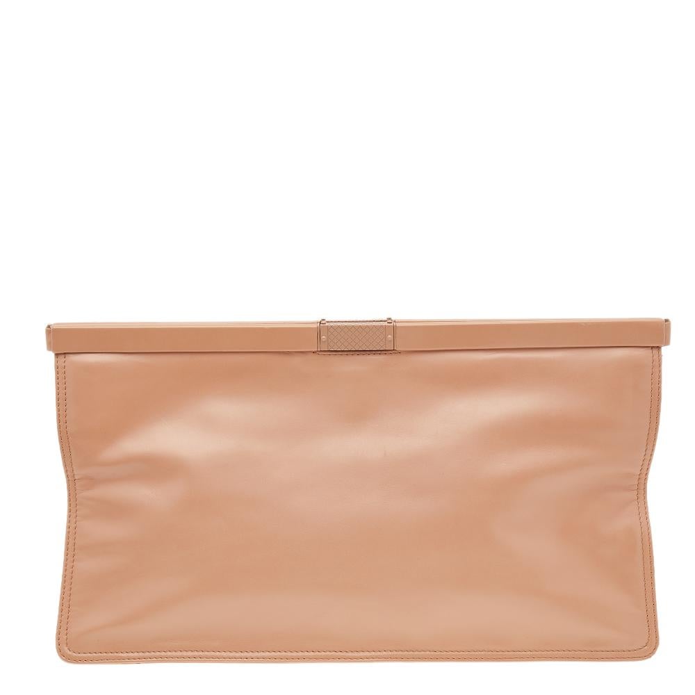This oversized clutch from Bottega Veneta is created lavishly to provide comfort, class, and style. It is made using beige leather and decorated with black-toned hardware. This piece comprises of a smart-structured shape that perfectly equips a