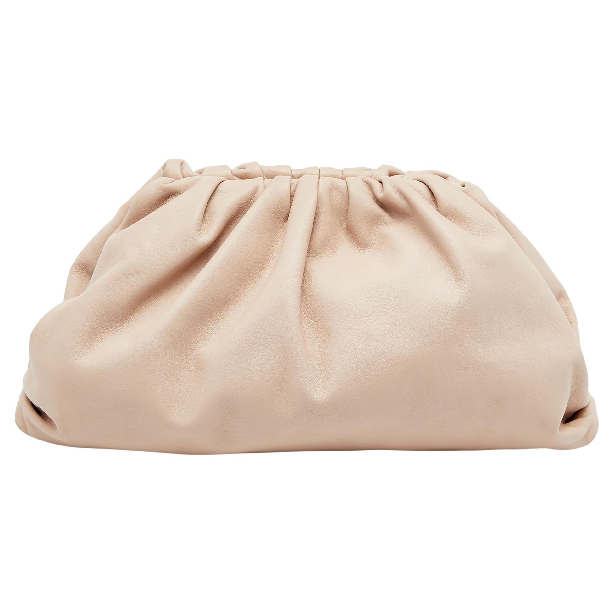 Combining minimal aesthetics with modern nuances comes easy to Bottega Veneta. Giving power to the same, we have this Teen Pouch Clutch in beige leather. It has a soft construction with ruching on the uppers. Lovely tucked under your arm or clasped