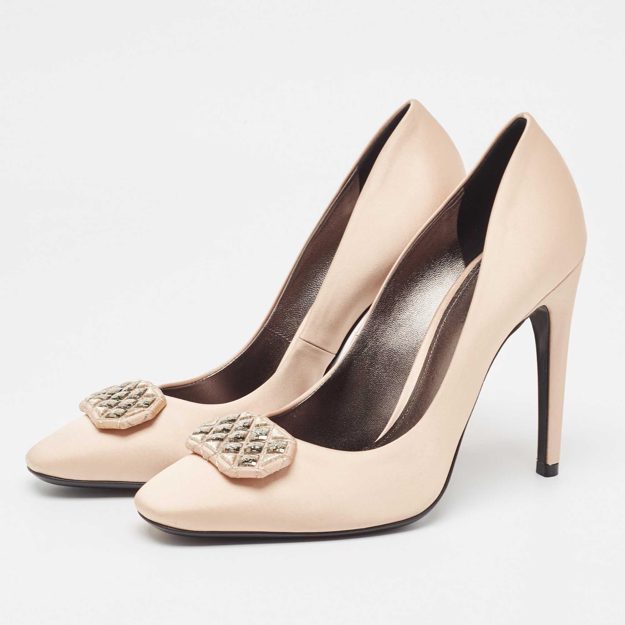 Add a curvy edge to your feet as you put on these stunning pumps from the House of Bottega Veneta. Their exterior is created using beige satin which is enhanced with a studded embellishment on the upper 11.5 cm heels and a slip on style. Let your