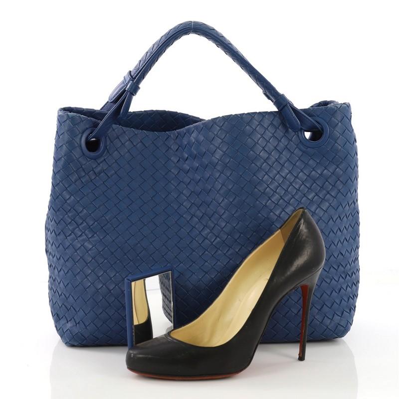 This Bottega Veneta Bella Tote Intrecciato Nappa Large, crafted from blue intrecciato nappa leather, features dual looped handles with all-around braided details and gunmetal-tone hardware. It opens to a taupe microfiber interior with zip and slip