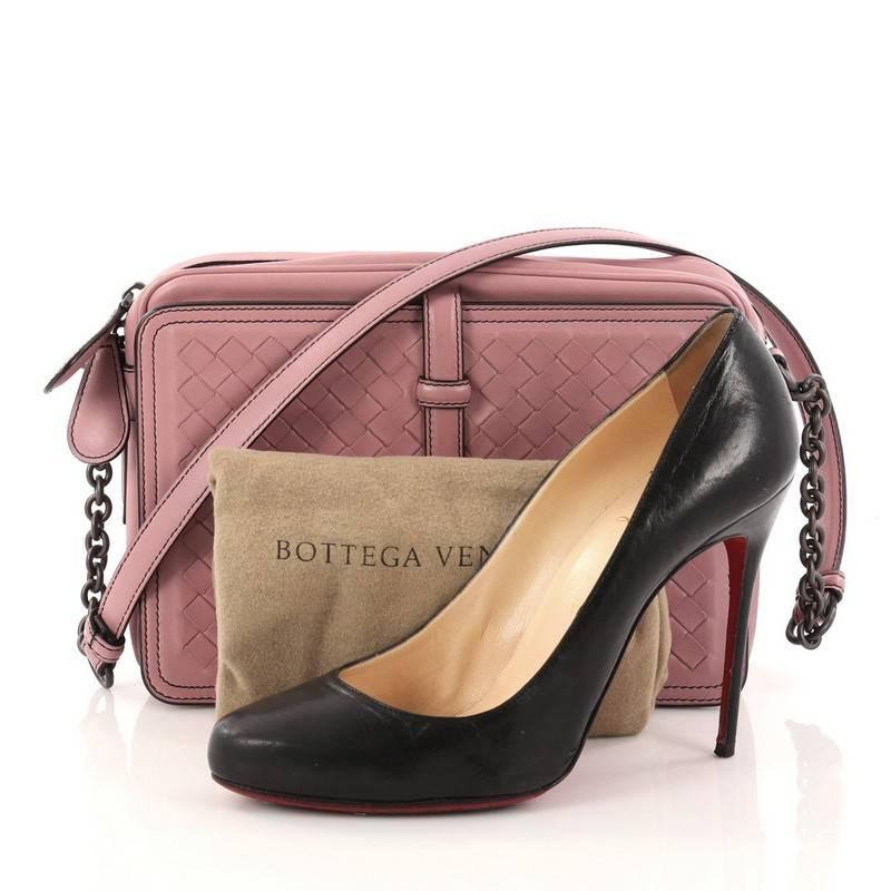 This authentic Bottega Veneta Belt Flap Camera Bag Intrecciato Nappa Small is a classic and elegant bag perfect for on-the-go fashionista. Crafted from light mauve pink leather woven in Bottega Veneta's signature intrecciato method, this modern bag