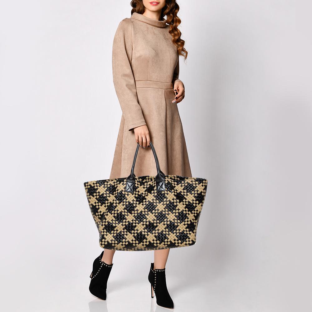 One look at this Cabat tote from Bottega Veneta and you'll know why it is luxe. Woven using black and beige leather in their Intrecciato technique and held by two rolled handles, it is brimming with artistry and quality craftsmanship. The bag is