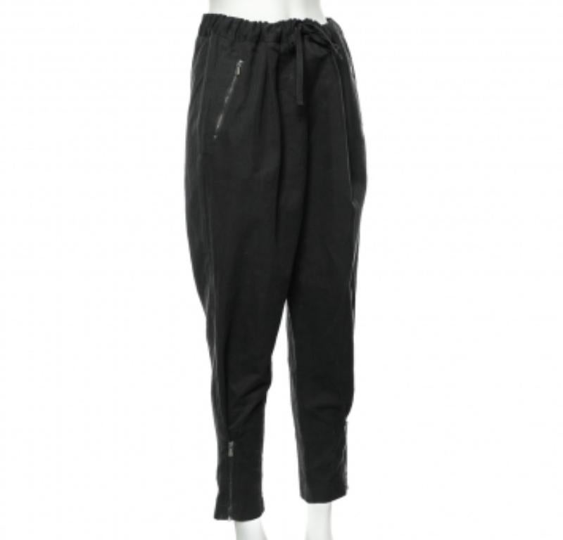 Pasa el día con lujo y estilo con estos pantalones de la Casa Bottega Veneta. Están confeccionados en tejido de algodón negro y llevan un detalle de cremallera. Están provistas de dos bolsillos exteriores. ¡Añádelos a tu armario hoy mismo!