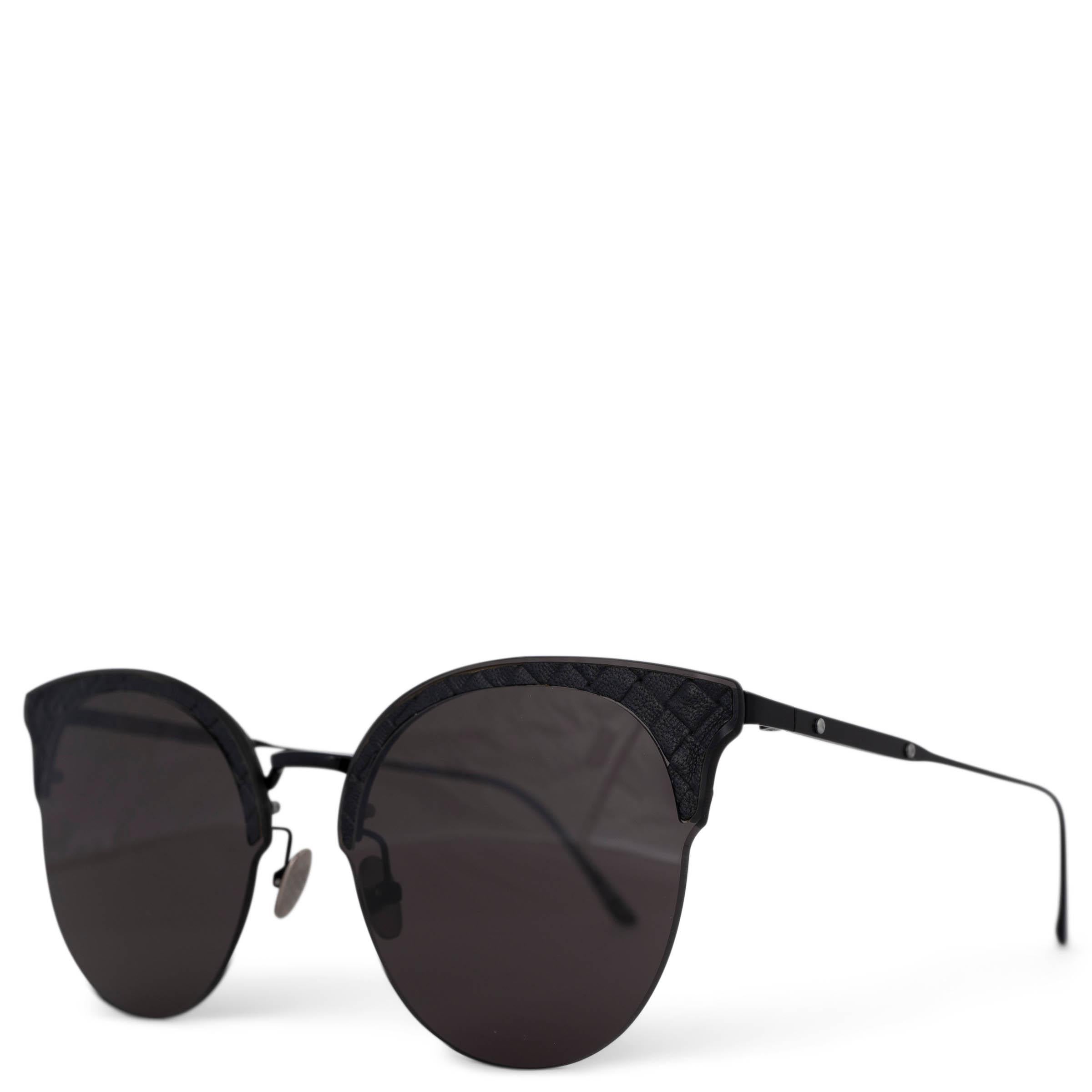 These 100% authentic Bottega Veneta cat-eye sunglasses are crafted from sleek black metal with grey lenses, featuring a sophisticated semi-rimless design. The signature black Intrecciato leather details add a luxurious touch, making these sunglasses