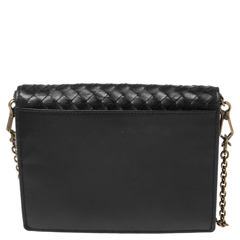 This crossbody bag from the House of Bottega Veneta will be your favorite bag in no time. It has been designed using black Intrecciato leather on the exterior and flaunts a gold-toned chain strap. The spacious fabric-lined interior houses all your