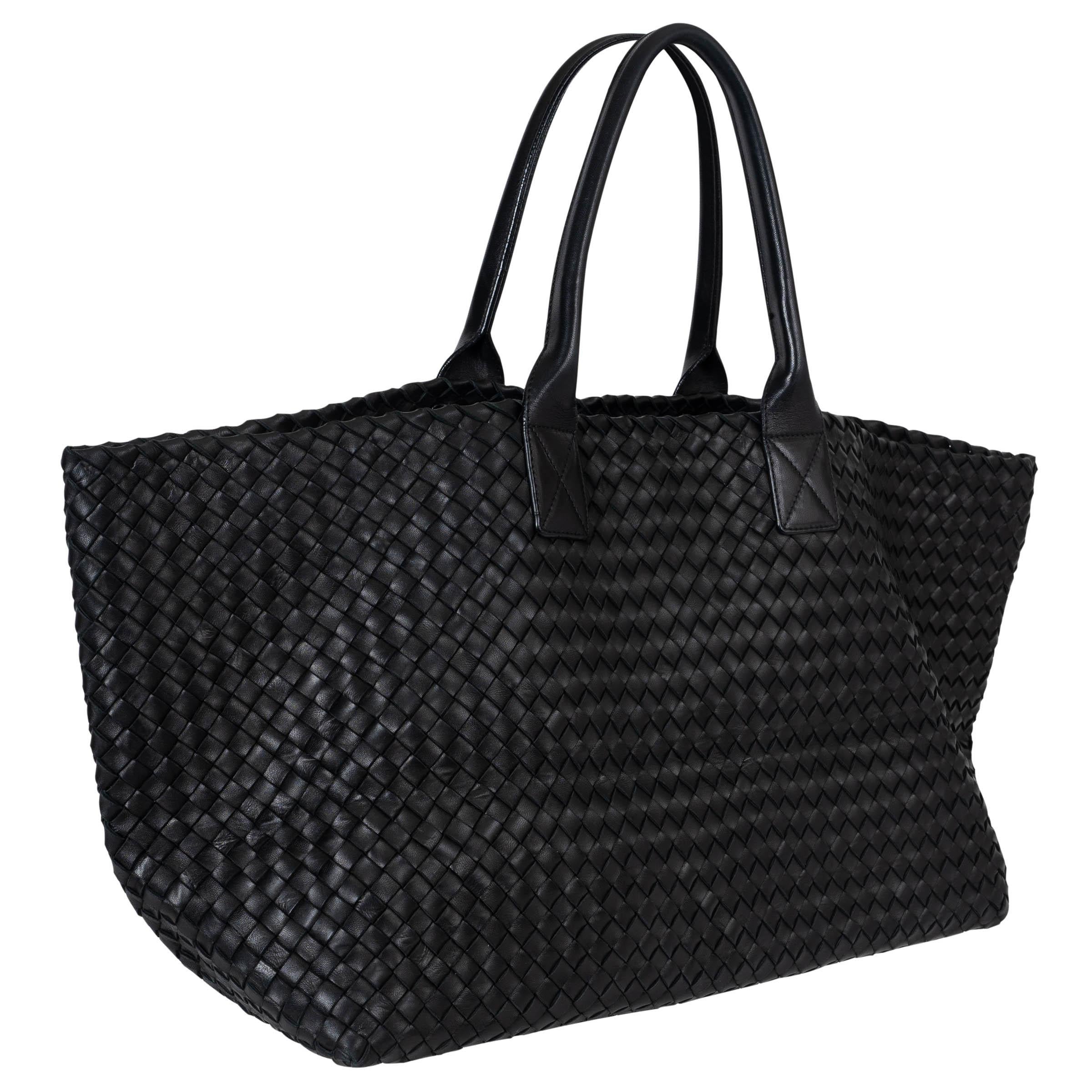 Ce grand sac cabat noir intrecciato 100% authentique de Bottega Veneta est une représentation emblématique du luxe et de l'artisanat. Tissé à la main selon la technique intrecciato emblématique de la marque, ce fourre-tout est doté d'un intérieur