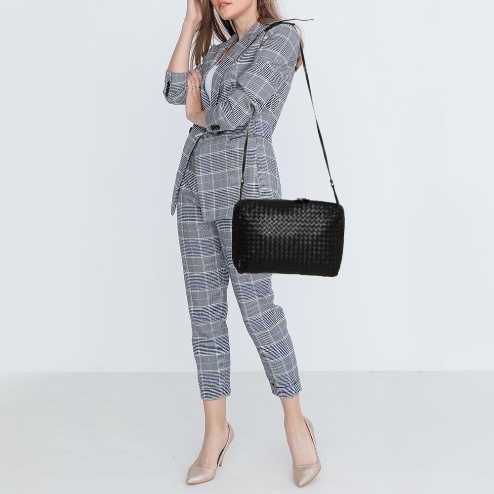 This Nodini bag from Bottega Veneta is crafted from black leather using their signature Intrecciato weaving technique flaunting a seamless silhouette. This shoulder bag, personifying elegance and subtle charm, is held by a long shoulder strap.