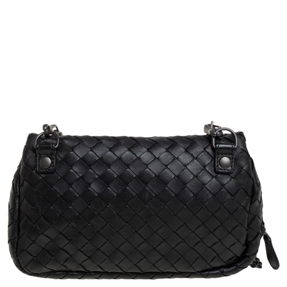 This crossbody bag from Bottega Veneta is what your wardrobe has been missing all this while! This lovely black bag is crafted from leather in the signature Intrecciato pattern and features a single chain link. The front flap opens to a suede-lined