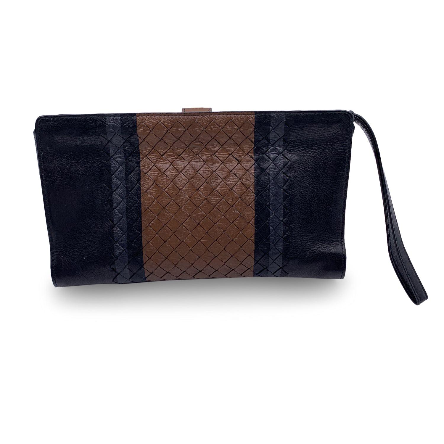 Bottega Veneta black intrecciato wrist bag. Black, brown and grey color. Button closure. It features 2 zipped pockets, a pen holder, 6 credit card slots and an open pocket to hold everything, from your cards to receipts and documents. 'Bottega