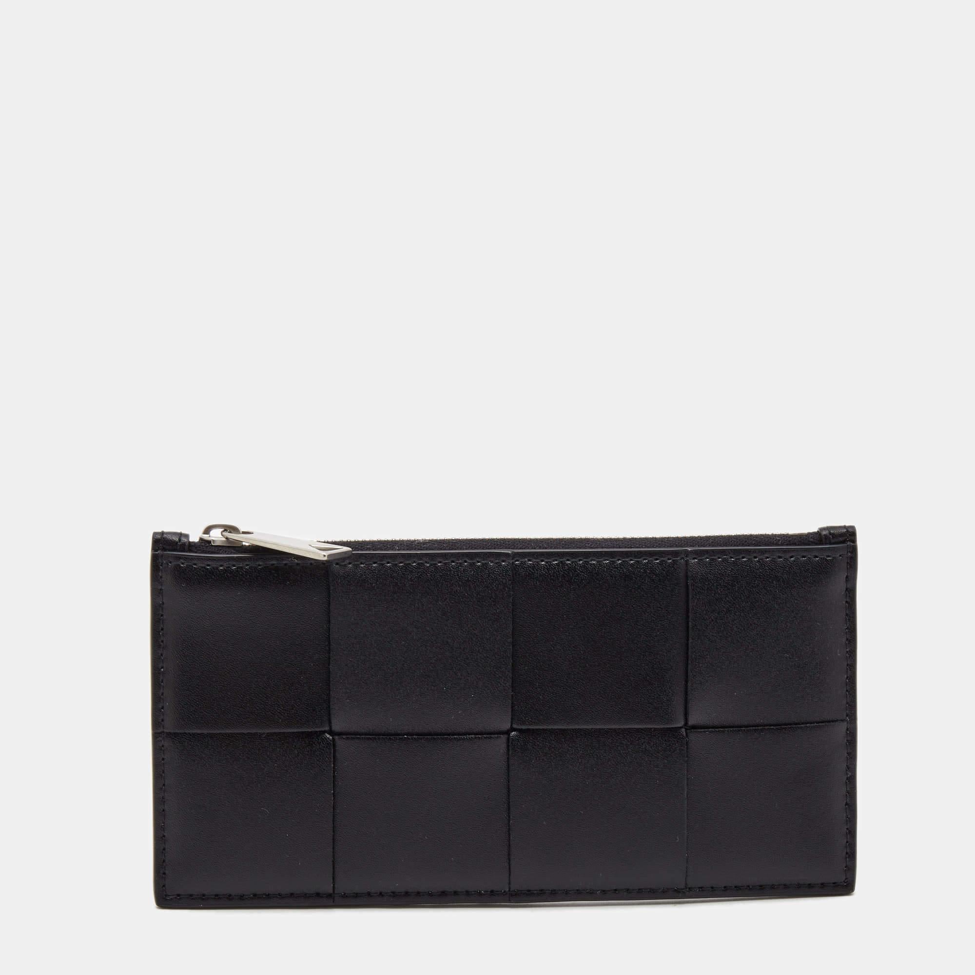 Crafted out of quality leather in their signature Intrecciato pattern, this card-holder by Bottega Veneta comes equipped with multiple slots that will dutifully hold your cards and a zipped compartment. This piece is sleek and can easily slip into