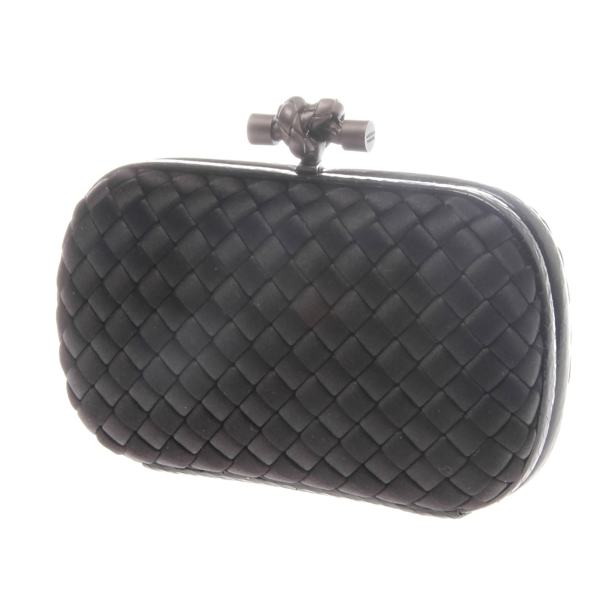 A mystery black clutch crafted in BOTTEGA VENETA Signature Intrecciato woven style that will hold its own against any glamorous evening look.
Oro matte black intrecciato woven mesh body with snakeskin trim.
Tonal matte hardware.
Hard-shell body