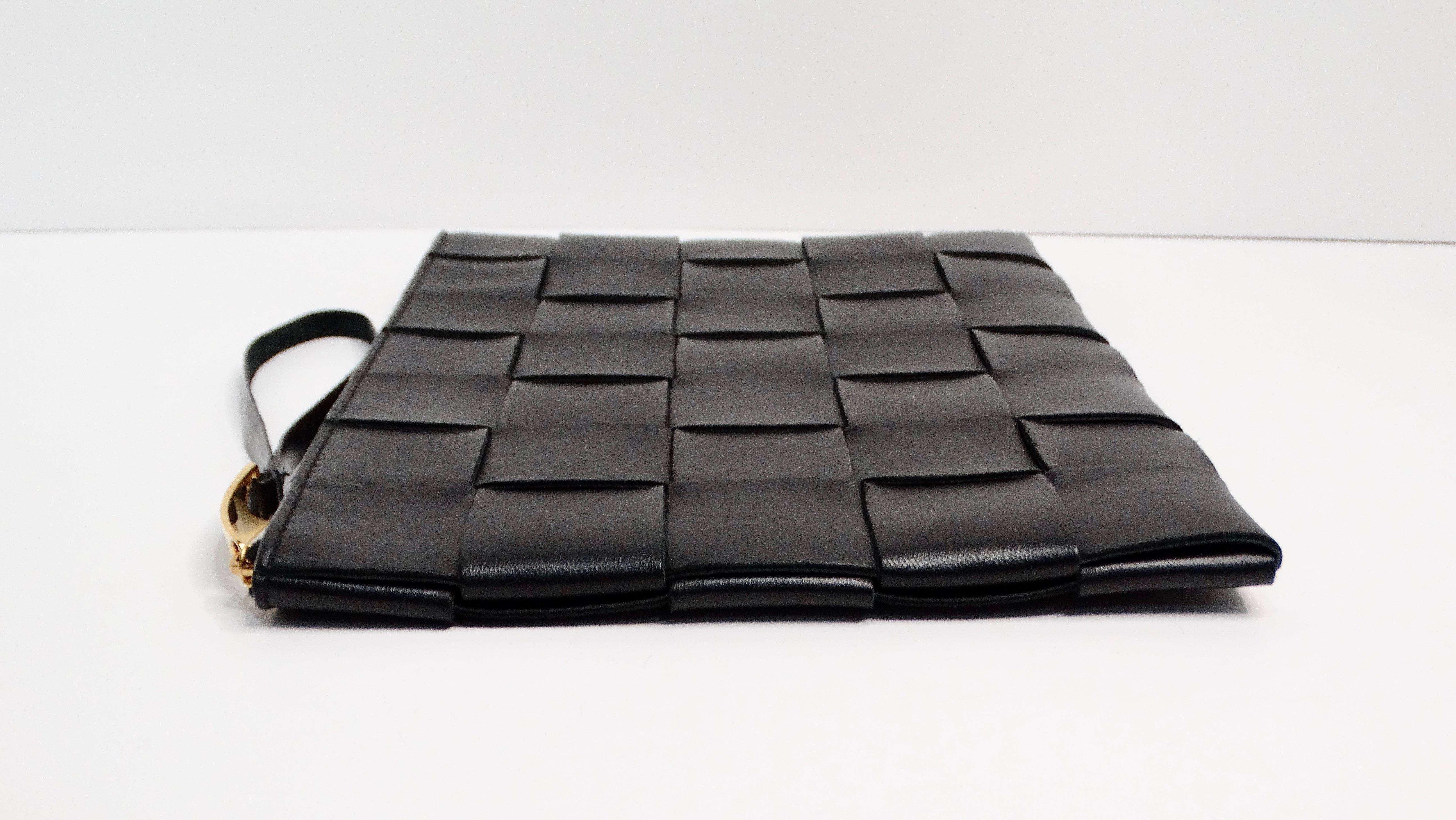 The Bottega Veneta Black Intreccio Leather Wrist Pouch is a timeless blend of elegance and practicality. Featuring a zip closure with a wristlet zipper and gold-tone accents, this pouch showcases the signature large square weft Bottega style. Its