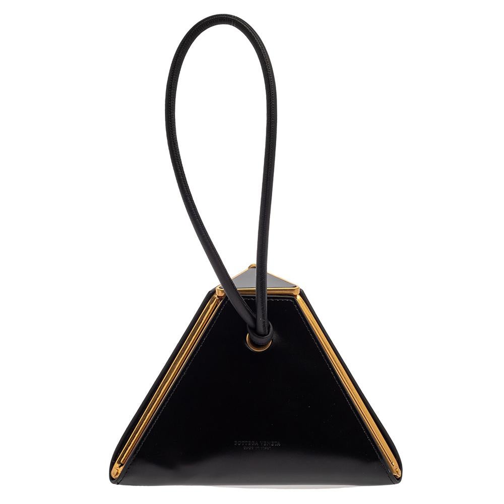 Bottega Veneta's Pyramid clutch is truly a work of art! The hinged and sculptural structure of the creation is crafted from black leather, and the triangular fastening opens to reveal a compact interior. Carry it with your evening ensemble for a