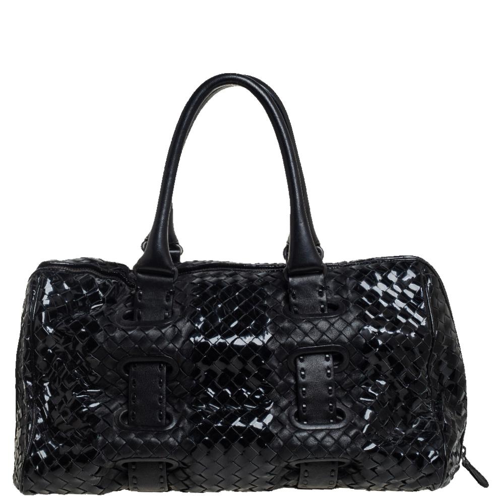 Bottega Veneta's Boston bag is elevated by the timeless Intrecciato craftsmanship. Minimal in design but high in allure, this designer bag in black patent leather has two handles, a compact size, and a suede interior.

Includes: Original Dustbag
