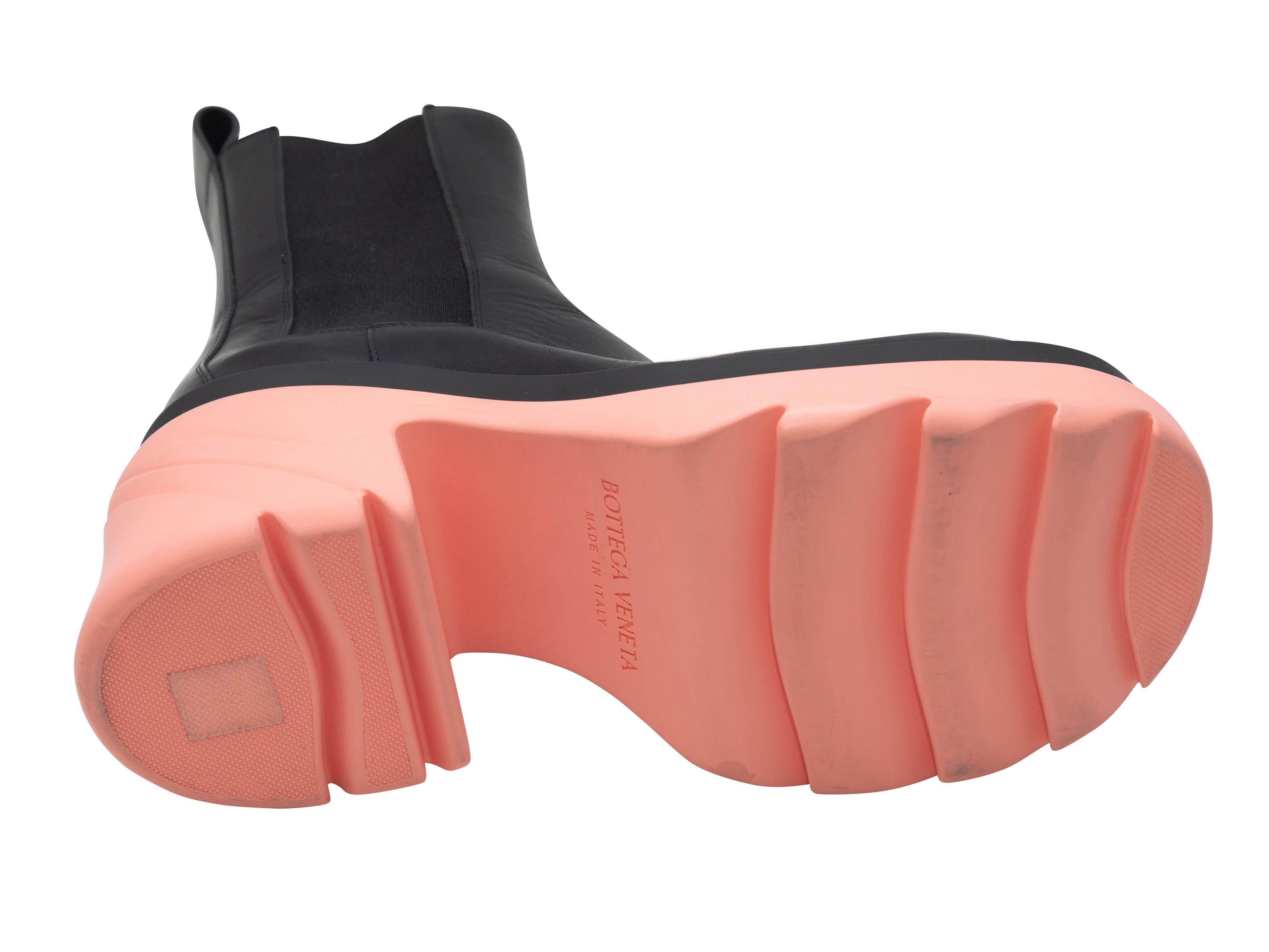 Product Details: Black leather Flash pull-on platform ankle boots by Bottega Veneta. Elasticized gores at sides. Pink rubber soles. 1.5