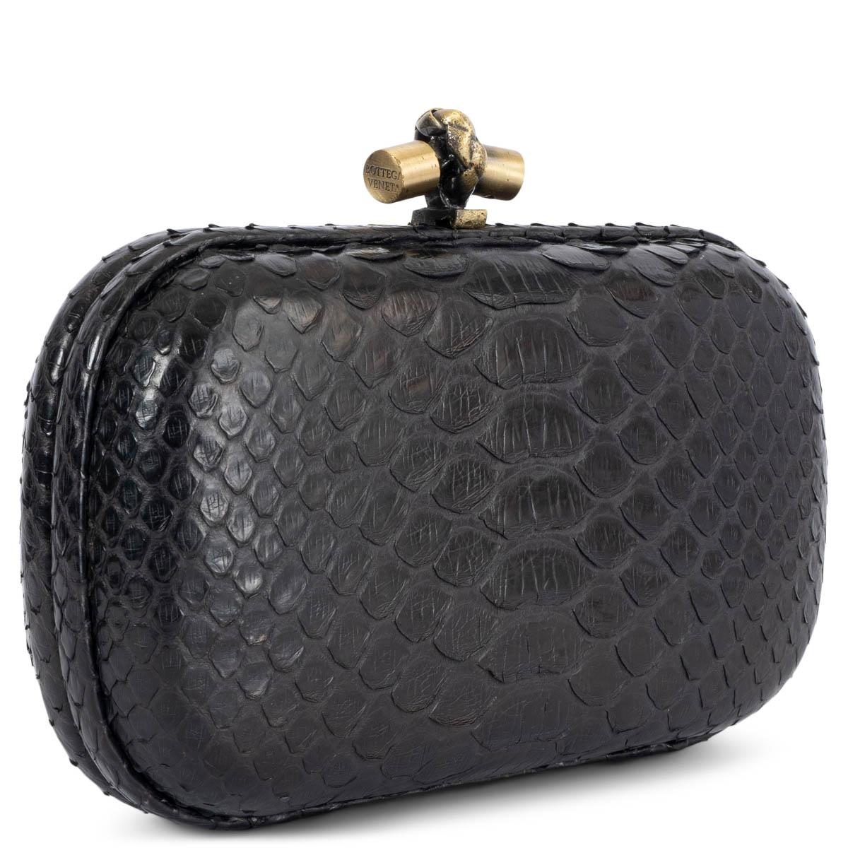 100% authentic Bottega Veneta Knot clutch in black python with grey suede lining and antique gold-tone knot closure. Has been carried and shows some yellow marks on the lining and a soft smoke odor. Overall in very good condition.