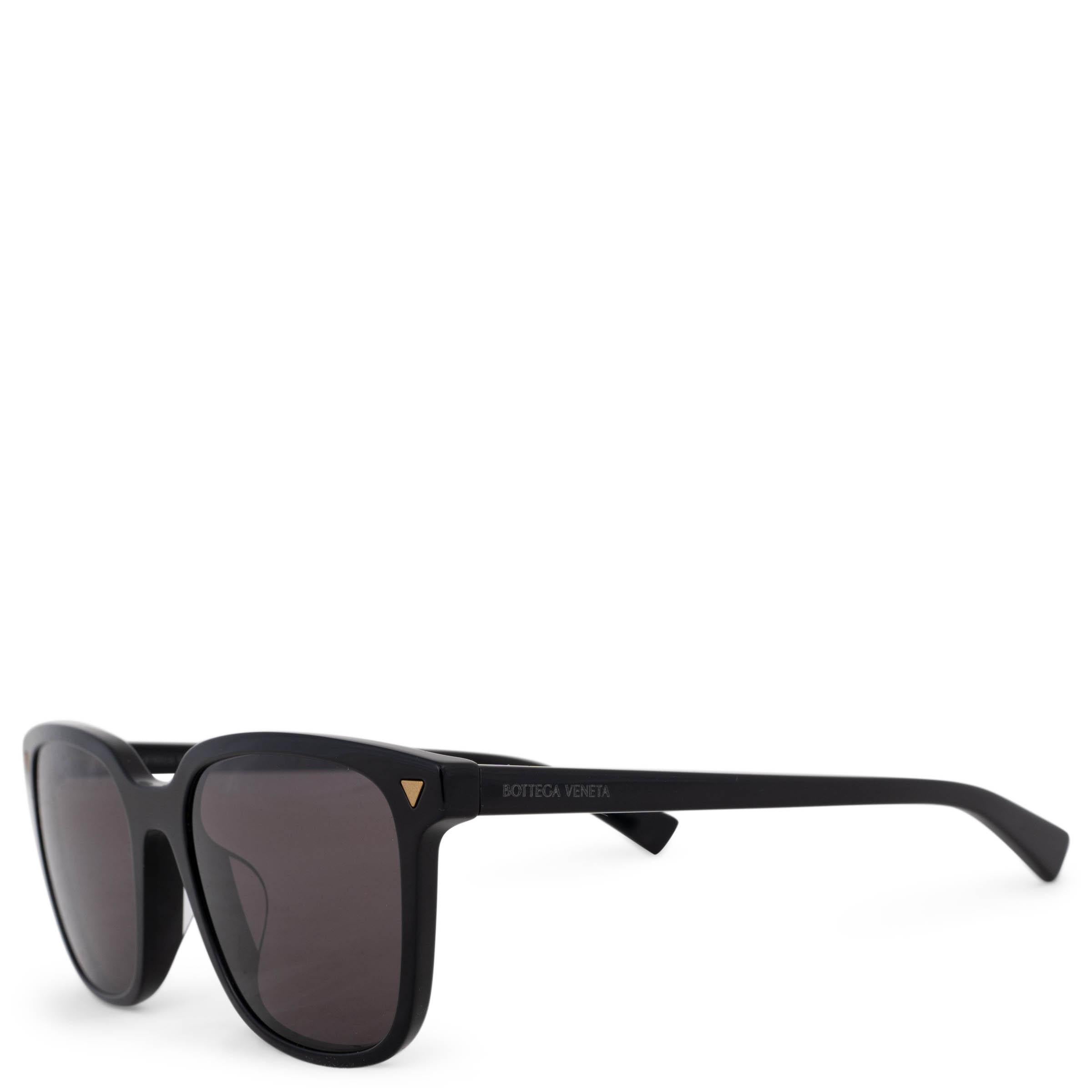 This 100% authentic Bottega Veneta square sunglasses in black acetate exude modern sophistication with a bold, structured silhouette. Featuring grey lenses for a sleek finish, they are subtly accented with small gold-tone triangle details and