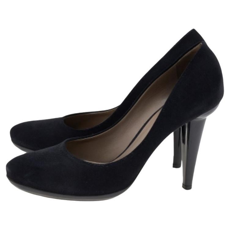 Estos zapatos de salón de la casa Bottega Veneta te ayudarán a dar cada paso con confianza, lujo y estilo. Están confeccionadas con ante negro y charol en el exterior. Presentan puntera cubierta, estilo slip-on y tacón de 12 cm. Estos zapatos de