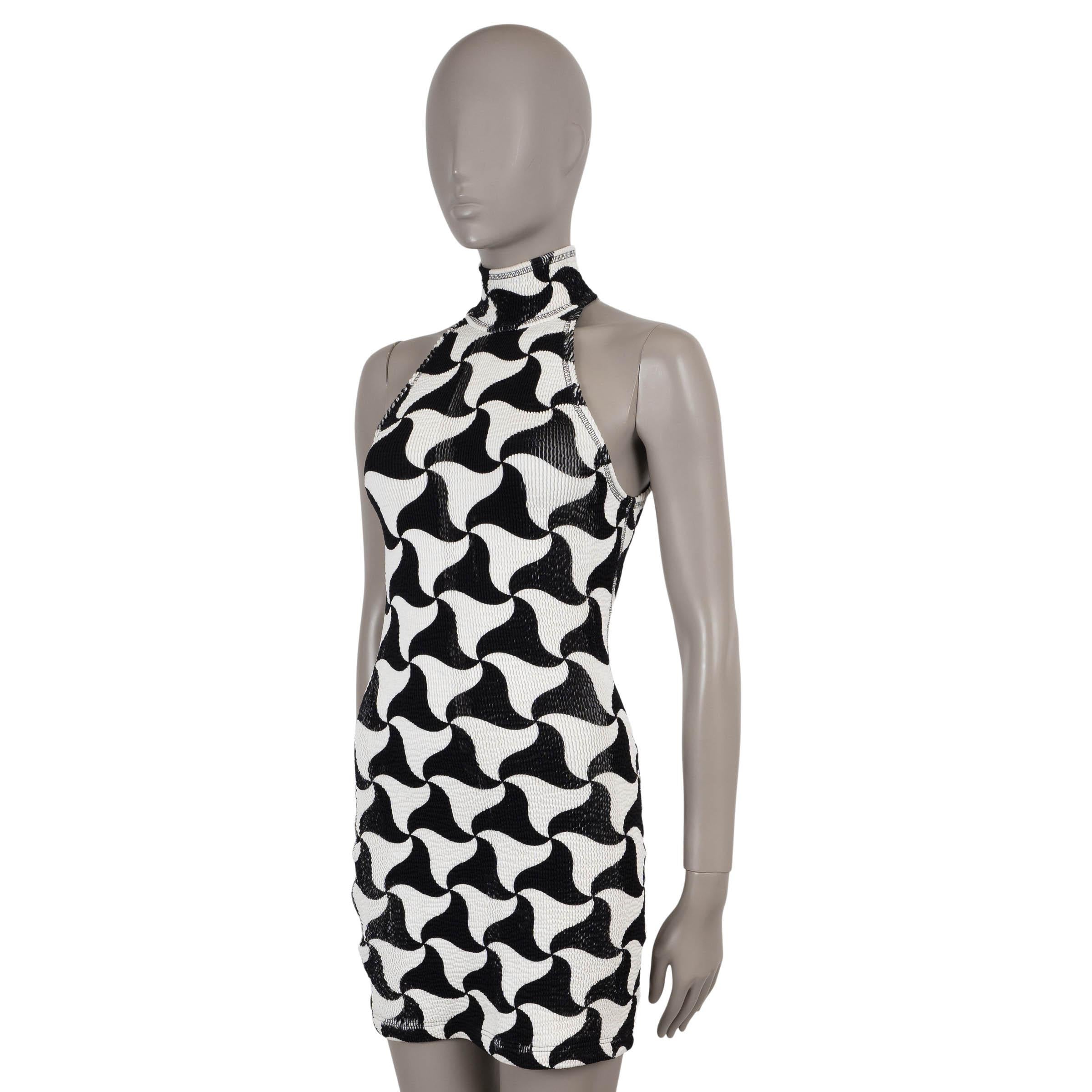 Questo abito Bottega Veneta, autentico al 100%, è realizzato in seersucker elasticizzato bianco e nero (misto poliammide-elastan) con un'audace stampa a triangoli ondulati. La silhouette elegante e senza maniche abbraccia il corpo con una scollatura