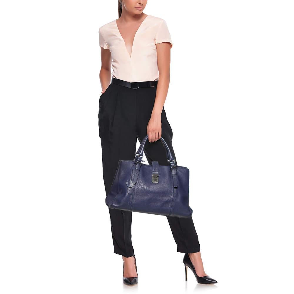 This Bottega Veneta tote is a creation that delights one's sight! It has been beautifully crafted from leather and designed with two top handles, a front push-lock, and three suede compartments that will dutifully hold all your belongings. We