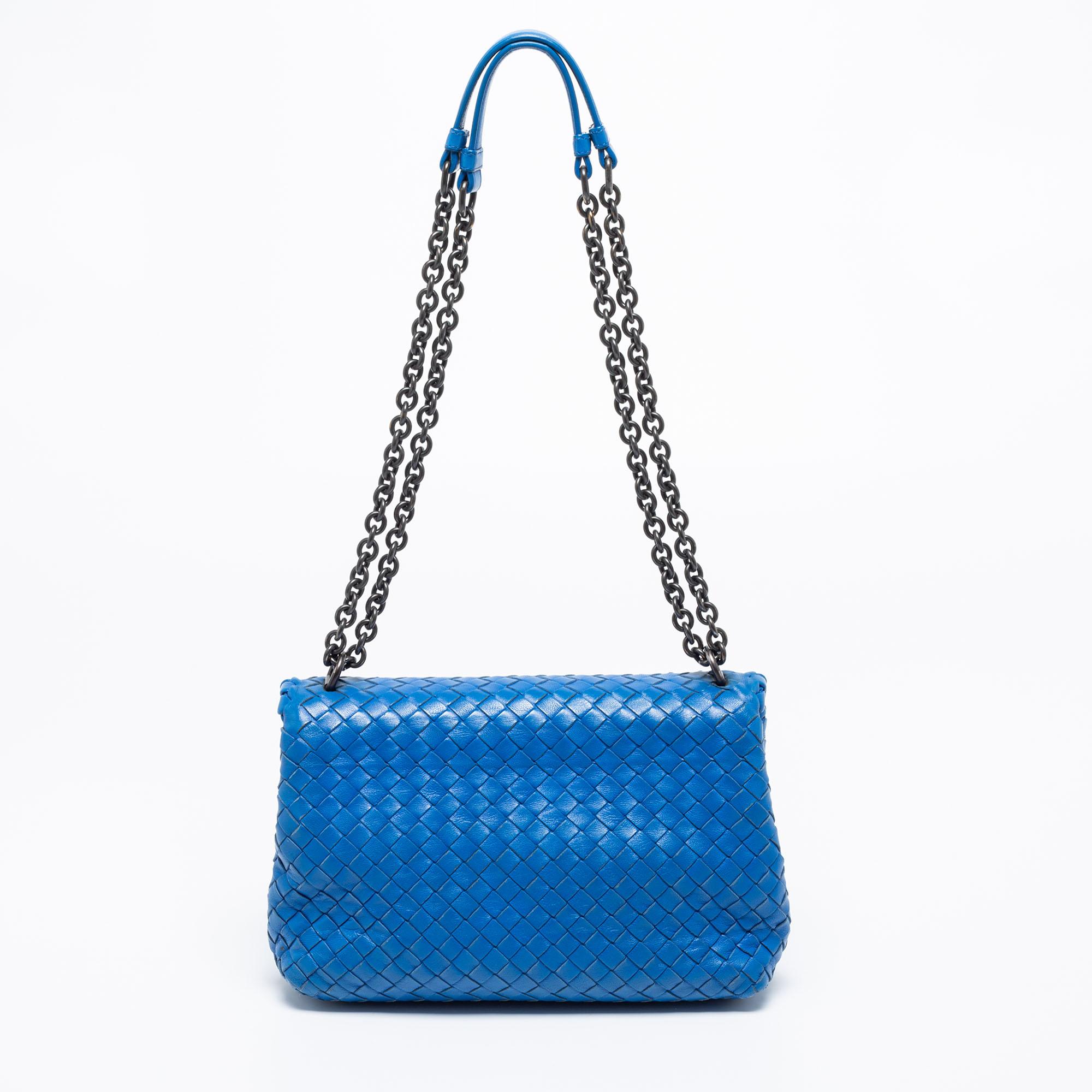 Named after the renaissance building 'Teatro Olimpico,' the Bottega Veneta Olimpia bag reflects the brand's faultless weaving technique. This blue creation comes made from Intrecciato leather and is held by dual chain-leather handles at the top.