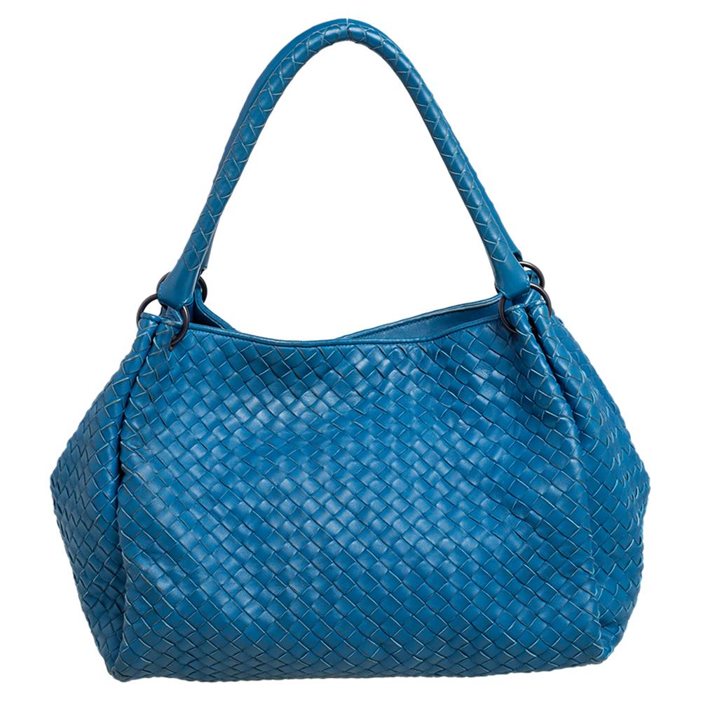 Showcasing a refreshing design, this Bottega Veneta handbag ideally complements your look. Crafted in Italy, it is made of blue leather and features the brand's iconic Intrecciato weave throughout. This Parachute bag is held with dual handles, has a